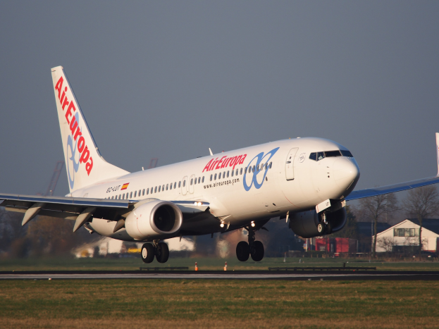 Air Europa Airbus A330-300 startet von Frankfurt Airport mit Gras darunter, Gebäuden und Bäumen im Hintergrund und einem klaren blauen Himmel darüber.