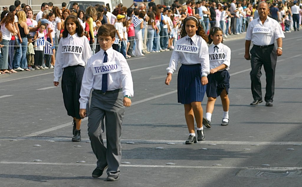Menschen auf einer Straße bei einem Ereignis, mit Abzeichen auf ihren Hemden, umgeben von einer großen Menge.
