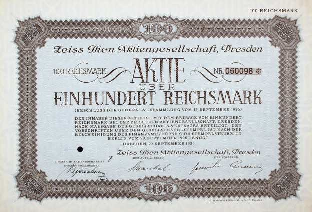 Schwarzumrandetes deutsches Aktienzertifikat mit der Aufschrift "Aktie über Einhundert Reichmark", das einen Wert von 100 Reichmark angibt.