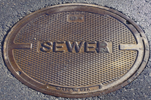 Metallschachtdurchlass auf der Straße mit der Prägung "Kanal"