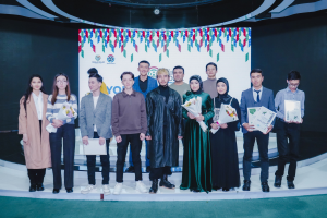 Eine Gruppe von Menschen auf einer Bühne mit Blumensträußen und Urkunden, vor einem Hintergrund mit der Aufschrift "Jugend-Solar-Awards 2019".