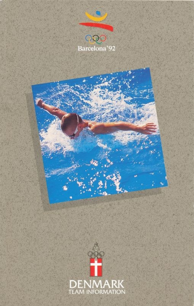 Plakat mit einem Schwimmer in einem blauen Anzug mit ausgestreckten Armen im Wasser, unter einem blauen und weißen Logo der Olympischen Spiele Barcelona 1992 und dem Text "Denmark Team Information", vor einem hellblauen Himmel mit weißen Wolken.