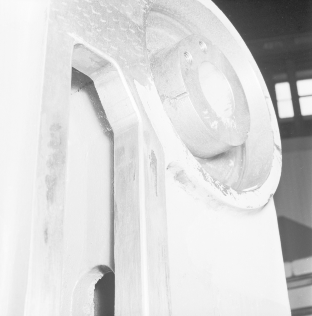 Nahaufnahme einer glänzenden, detailreichen Fräsmaschine in einer Fabrik mit einer Wand und Fenstern im Hintergrund.
