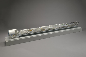 Ein detailliertes Modell des neuen Wasserstoff-Brennstoffzellensystems von Sainsbury auf einer weißen Oberfläche, das einen Kraftstofftank, einen Filter, eine Einspritzdüse und eine Energiequelle zeigt und ihre Verbindungen demonstriert.