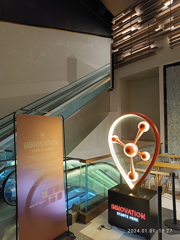 Großes Schild in einem Gebäude mit einer Treppe im Hintergrund, das "Innovation Starts Here" auf der linken Seite und Tische mit Stühlen auf der rechten Seite zeigt, was auf die HSTP20 Expo hinweist.