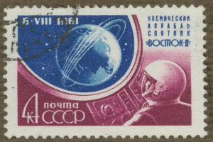 Eine Briefmarke mit einem Mann im Weltraumanzug mit entschlossener Miene, umgeben von Text, der "Marke" in fetter, weißer Schrift lautet.