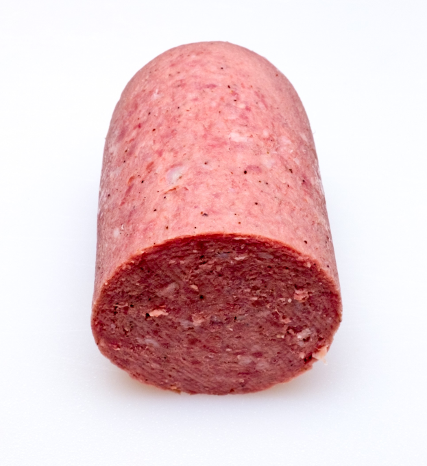 Ein Stück pink-roter Wurst mit rauer Textur auf einem weißen Hintergrund.