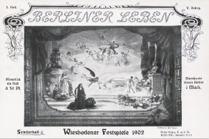 Schwarzes und weißes Foto einer Bühne von den Wiesbadener Festspielen 1902 mit Darstellern in traditioneller deutscher Tracht, bunten Bühnendekorationen und einem applaudierenden Publikum im Hintergrund.
