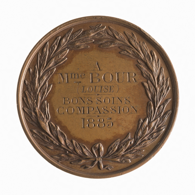 Bronze-Medaille mit Lorbeerkranz und der Aufschrift "Bons Soins Compassion" auf weißem Hintergrund.