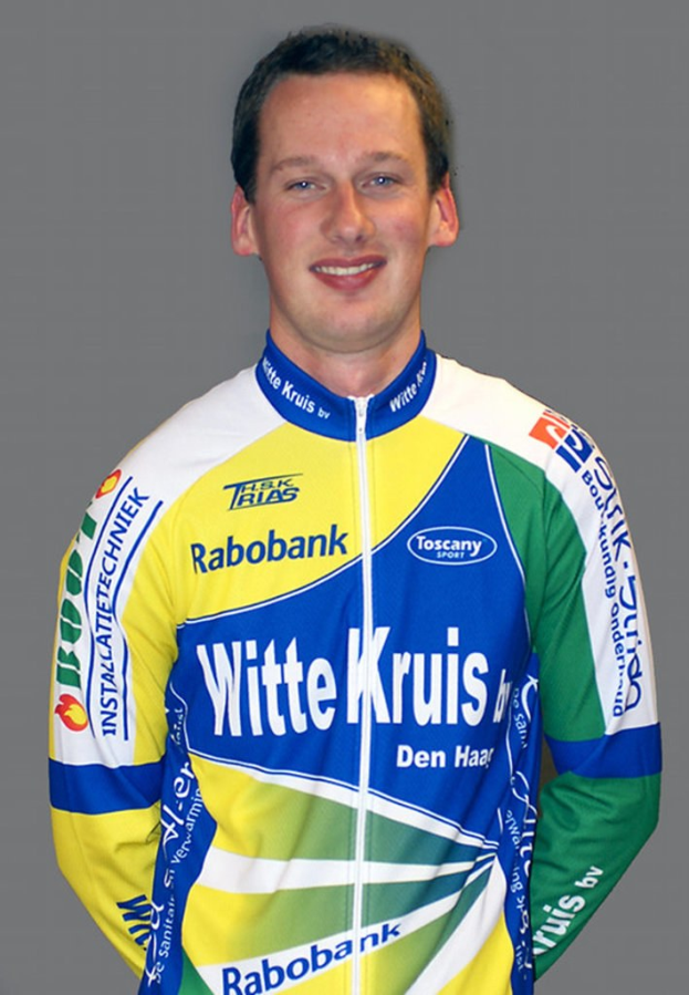 Ein männlicher Sportler posiert für ein Foto, auf dem sein T-Shirt mehrere Sponsorennamen trägt.