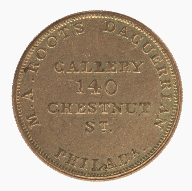 Goldmünze mit der Inschrift "M.A. Root's Daguerrean Gallery 140 Chestnut St. Philadelphia" auf einem weißen Hintergrund.