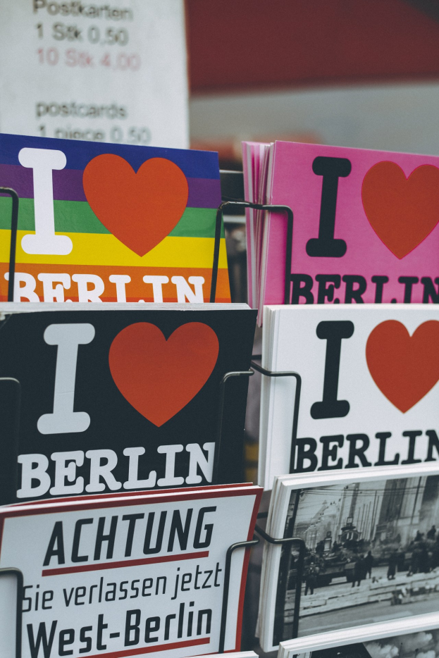 Ein Gestell mit Büchern und Postern, auf denen der Satz "Ich liebe Berlin" steht, vor einem leicht unscharfen, traumhaften Hintergrund.
