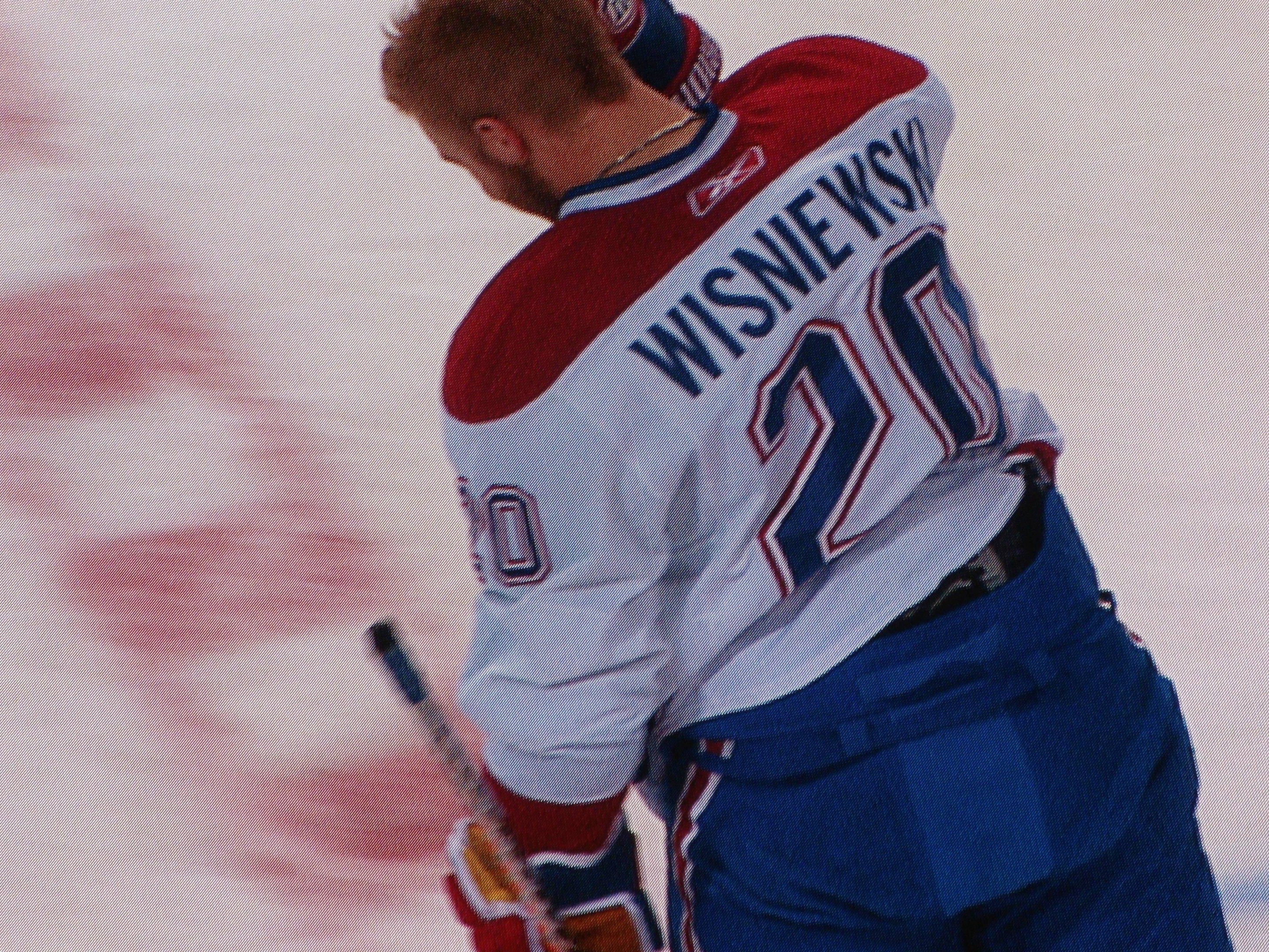 Professioneller Hockey-Spieler in einem "Wisniewski"-Trikot mit einem Hockey-Schläger auf dem Eis mit konzentrierter Miene