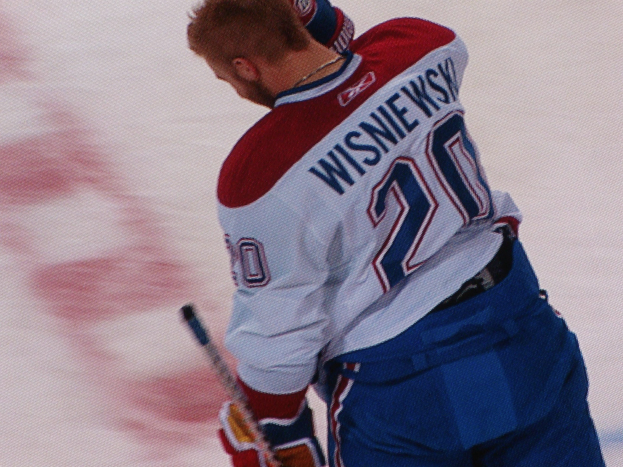 Professioneller Hockey-Spieler in einem "Wisniewski"-Trikot mit einem Hockey-Schläger auf dem Eis mit konzentrierter Miene